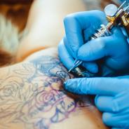 woman getting tattoo on her back